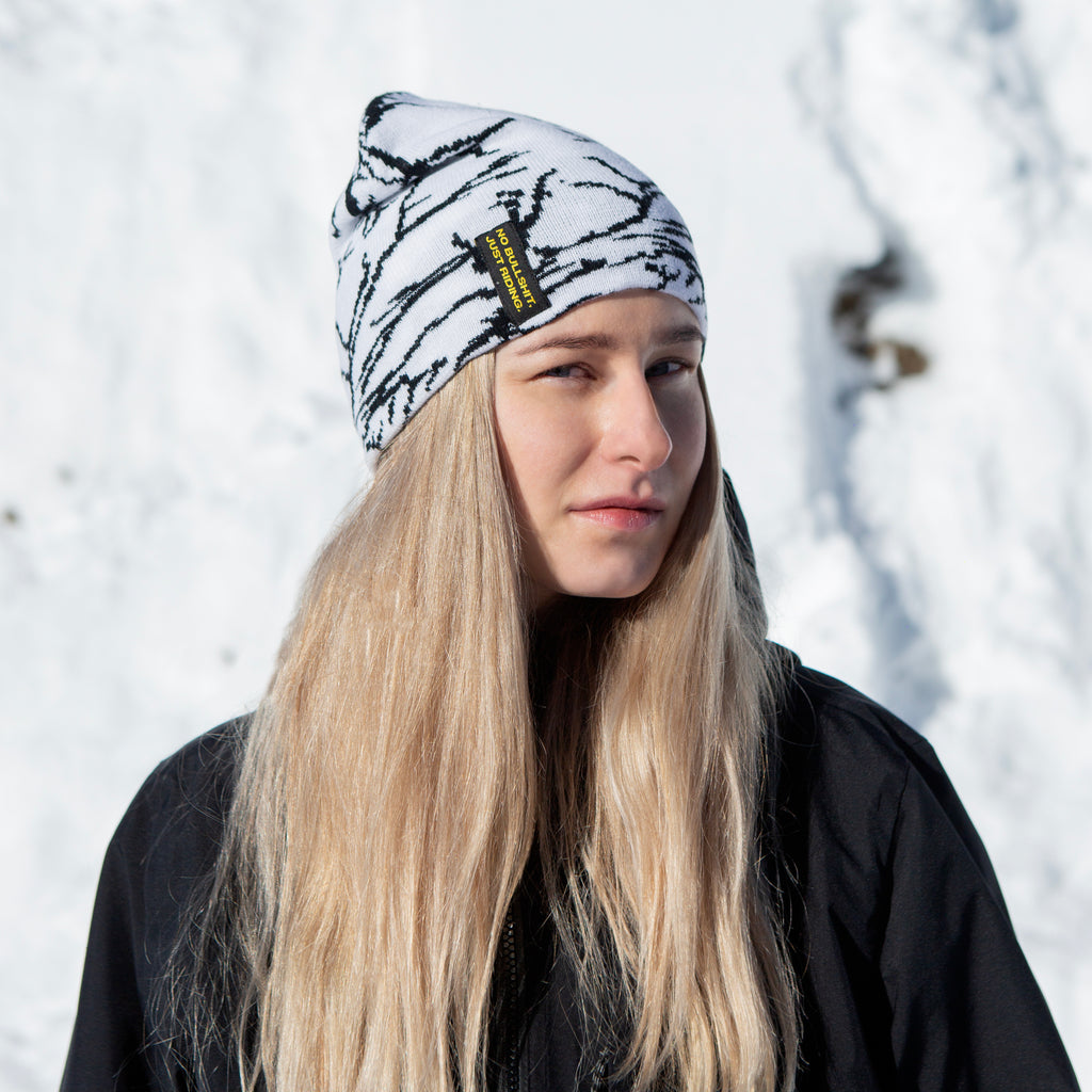 Stay warm and stylish with the NG Graphic Beanie. Featuring bold graphics and our signature 'No Bullshit, Just Riding' label, it's perfect for snowboarding, skiing, and everyday winter wear. 100% acrylic for comfort and durability. Shop now! White on Snow.