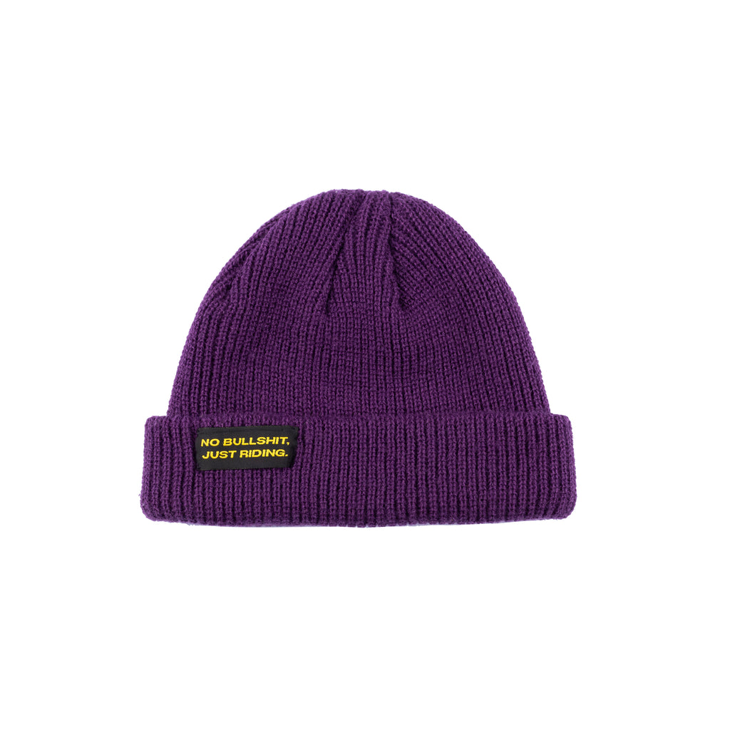 Shop our Kids Classic Beanie—small fit, 100% acrylic, perfect for kids who love snowboarding, skiing, and staying warm. Featuring the "No bullshit, just riding" label, this beanie combines style and warmth for all winter adventures. Ideal winter gear for young shredders! Kids Model. Purple Color.